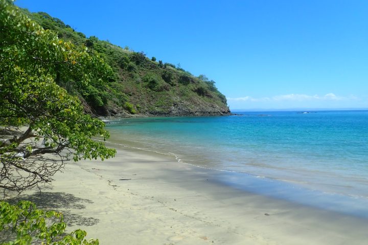a sandy beach next to a body of water