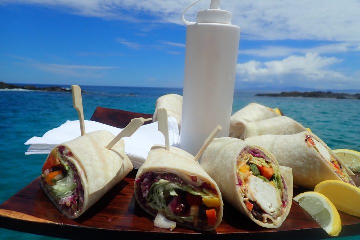 a close up of a picnic table sitting next to a body of water