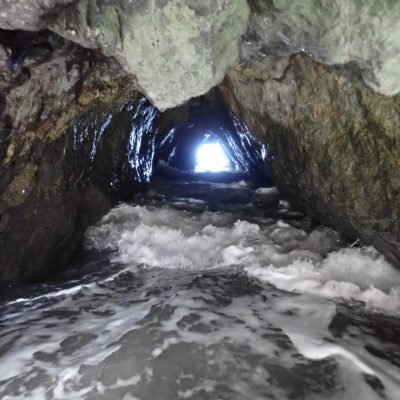 a large waterfall next to a rock