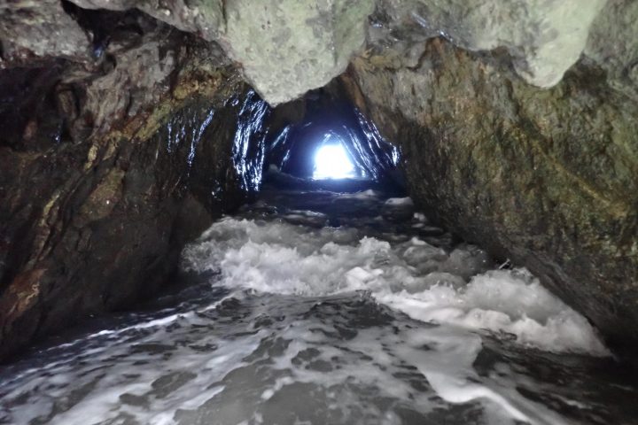 a large waterfall next to a rock