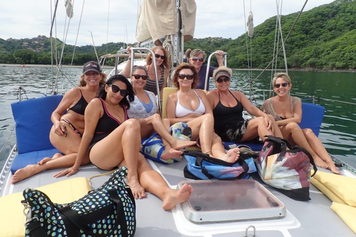 a group of people sitting on a boat posing for the camera