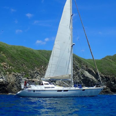 a small boat in a body of water with a mountain in the background