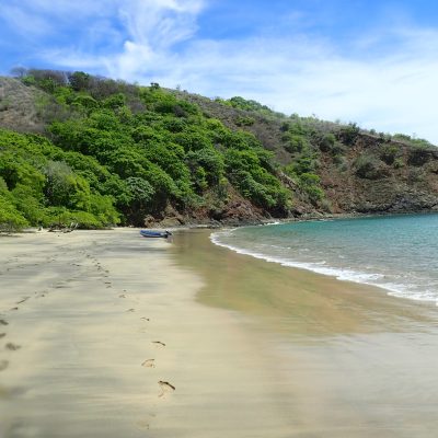 a sandy beach next to a body of water