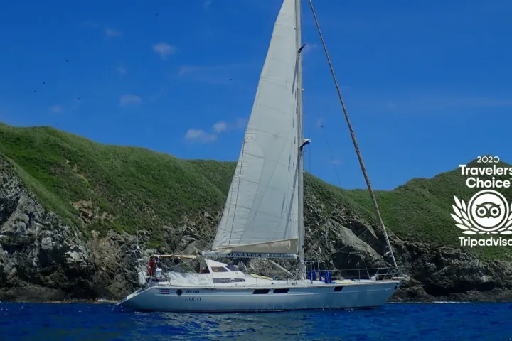 a small boat in a body of water with a mountain in the background