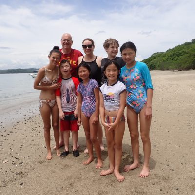 a group of people standing on a beach posing for the camera